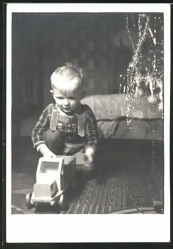 Fotografie Weihnachten, Knabe spielt mit Holzspielzeug unter dem Weihnachtsbaum 1941