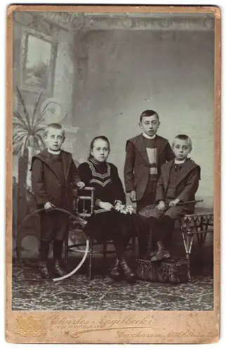 Fotografie Charles Angelbeck, Cuxhaven, Mittelstrasse 2, Portrait junges Mädchen im Kleid und drei Jungen mit Reifen