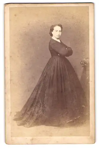 Fotografie J. Davicce, Ort unbekannt, Portrait junge Frau im schwarzen Kleid mit verschrenkten Armen
