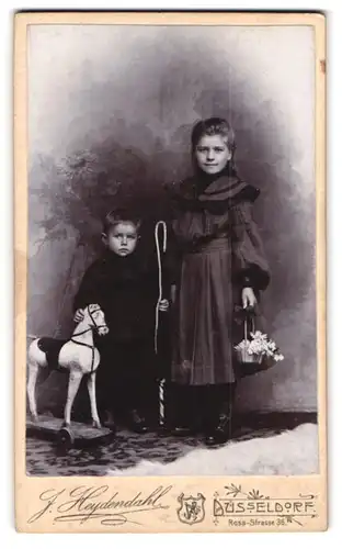 Fotografie J. Heyendahl, Düsseldorf, Ross-Str. 36, Portrait zwei Kinder mit Holzpferd und Blumenkorb