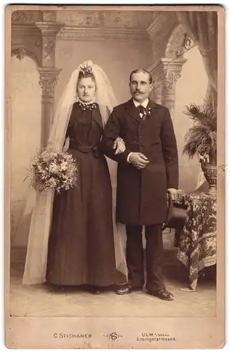 Fotografie C. Stichaner, Ulm a. Donau, Ensingerstr. 4, Portrait Paar im schwarzen Hochzeitskleid und Anzug mit Zylinder