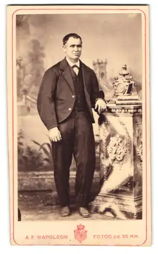 Fotografie A. F. Napoleon, Barcelona, Rambla Sta. Monica 19, Portrait Herr im Anzug stehend an einer Säule