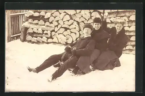 Foto-AK Herr und zwei Frauen auf Schlitten im Schnee