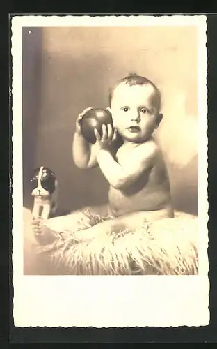 Foto-AK Nackiges Kleinkind mit Ball und Spielzeughund sitzt auf Fell