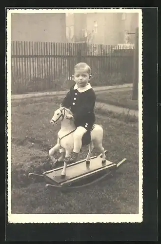 Foto-AK Kleiner Junge auf Schaukelpferd im Garten