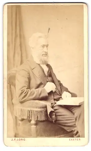 Fotografie J. F. Long, Exeter, 45, High Street, Portrait älterer Herr im Anzug mit Vollbart und Buch