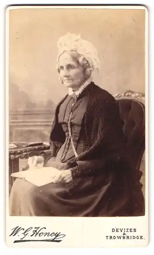 Fotografie Wm. G. Honey, Devizes, 3, High Steet, Portrait ältere Dame im Kleid mit Buch und Haube