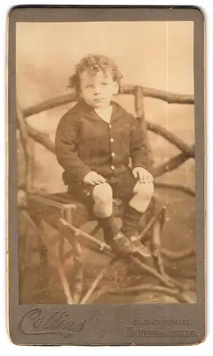 Fotografie Collins, Huddersfield, 24 John William St., Portrait niedlicher Bube mit lockigem Haar sitzt auf einem Stuhl