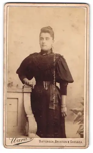 Fotografie Wara's, London, 521 King's Road, Portrait junge Schönheit mit Dutt im gerüschten Kleid