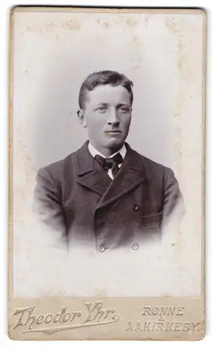 Fotografie Theodor Yhr, Rönne, Storetorv, Portrait junger charmanter Mann mit Fliege im Jackett
