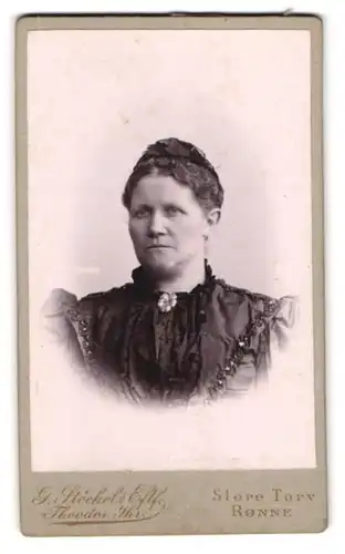 Fotografie G. Stöckel, Rönne, Store Torv, Portrait hübsche Frau mit Haarschmuck und Brosche am Kleiderkragen