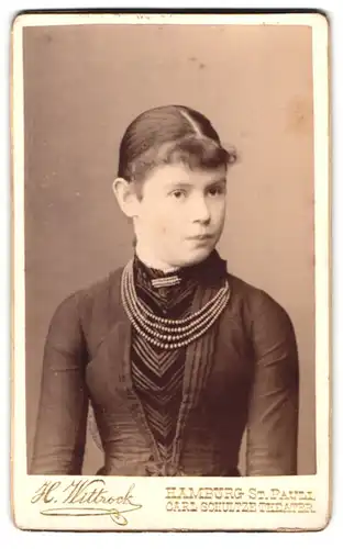 Fotografie H. Wittrock, Hamburg-St. Pauli, Portrait brünettes Fräulein mit Brosche und Perlenhalsketten