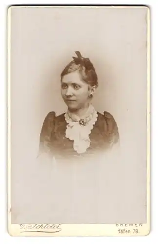 Fotografie C. Schlötel, Bremen, Häfen 78, Portrait brünette Schönheit mit Haarschleife und Brosche am Kleiderkragen