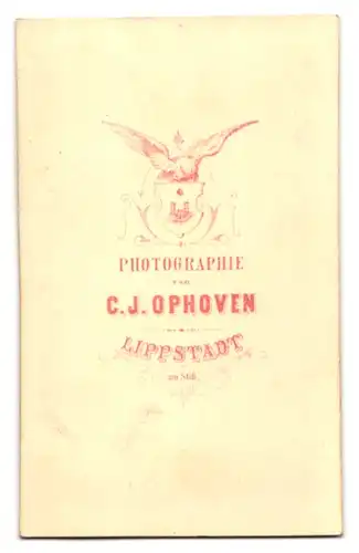 Fotografie C. J. Ophoven, Lippstadt, Portrait blonder frecher Bube auf einem Stein sitzend