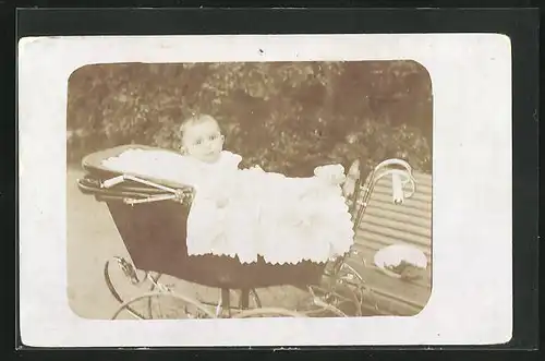 Foto-AK Baby blickt auf seinem Kinderwagen heraus