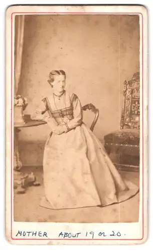 Fotografie Sands & Co., Surrey, Portrait einer elegant gekleideten Frau auf einem Stuhl sitzend