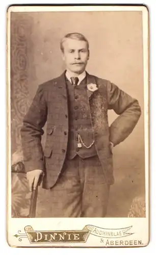 Fotografie A. Dinnie, Aberdeen, 3 Langstane Place, Portrait stattlicher Herr mit Schnurrbart und Ansteckblume am Jackett