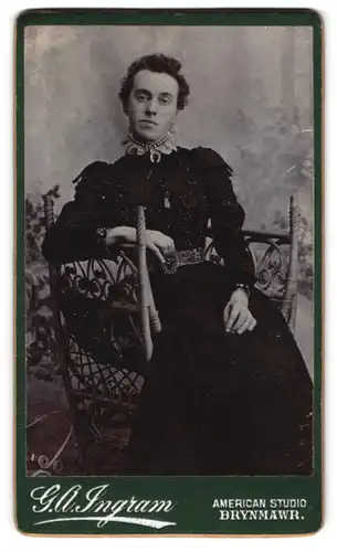 Fotografie G. A. Ingram, Brynmawr, Portrait dunkelhaarige Frau im schwarzen Kleid mit Perlenhalsschmuck