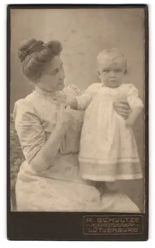 Fotografie R. Schultze, Lütjenburg, Portrait bürgerliche Dame mit Kleinkind im Arm