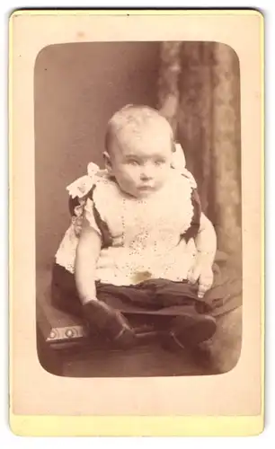 Fotografie Robert, Leigh, Portrait süsses Kleinkind im Kleid mit Schleifchen