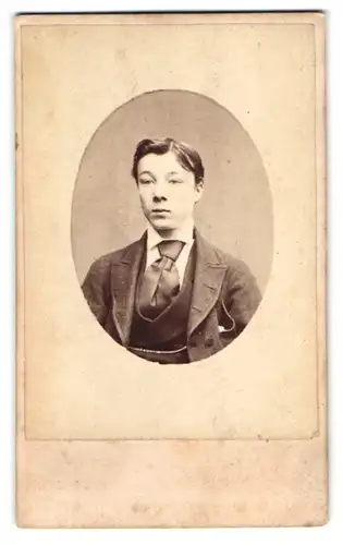 Fotografie W. H. Moore, Bristol, Merchant St., Brustportrait junger Herr im Anzug mit Krawatte