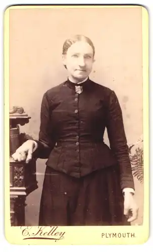 Fotografie E. Kelley, Plymouth, Old Town St. 31, Portrait Dame im dunklen Kleid mit Heilsarmee Abzeichen