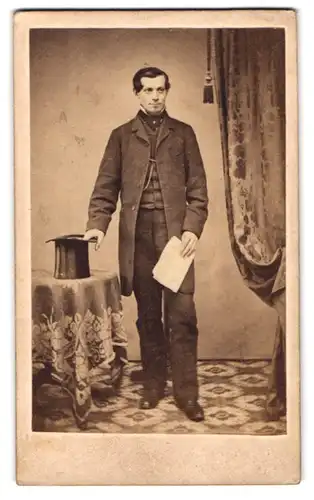 Fotografie unbekannter Fotograf und Ort, Portrait junger Mann im Anzug mit Zylinder posiert im Atelier