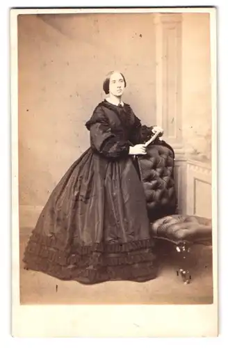 Fotografie Benj. Scott, Carlisle, Portrait Dame im reifrock Kleid lehnt an einem Stuhl