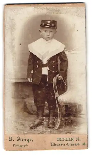 Fotografie R. Junge, Berlin-N., Elsasser-Strasse 35, Portrait kleiner Junge im Matrosenanzug mit Schirmmütze