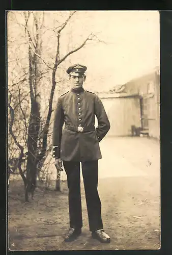 AK Soldat in Uniform rauchend vor einem Gehölz porträtiert
