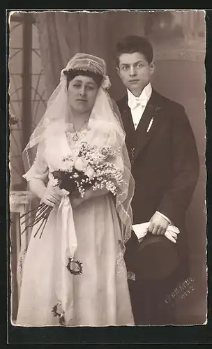 AK Hochzeit, junges Ehepaar, sie im Brautkleid mit Strauss und er im Anzug mit Zylinder