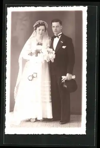 AK Hochzeit, Ehepaar, stehend portraitiert im weissen Kleid und schwarzen Anzug
