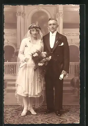 AK Hochzeit, Ehepaar, stehend vor einer Fotoleinwand in festlichen Kleidern