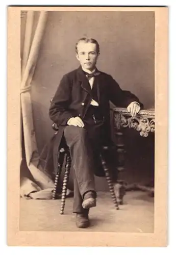 Fotografie unbekannter Fotograf und Ort, Portrait junger Knabe im Anzug mit Fliege poisert im Atelier