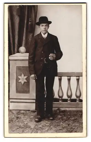 Fotografie Albert Steiger, Indersdorf, Portrait junger Knabe im dunklen Anzug mit Hut und Zigarre