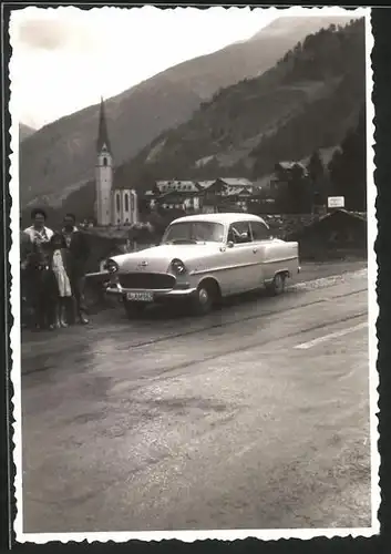 Fotografie Auto Opel, Familie nebst PKW vor einem malerischen Ort