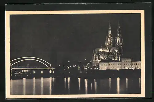 AK Köln am Rhein, Brücke und Dombeleuchtung bei Nacht