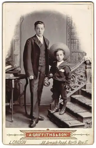 Fotografie A. Griffiths & Son, London-Bow, 98, Armach Road, Portrait junger Herr im Anzug mit kleinem Jungen