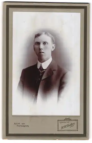 Fotografie H. H. Dudley, Ort unbekannt, Portrait junger Herr im Anzug mit Krawatte
