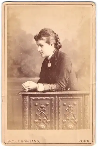 Fotografie W. T. & F. Gowland, York, Lendal, Portrait junge Dame mit Flechtfrisur und Amulett