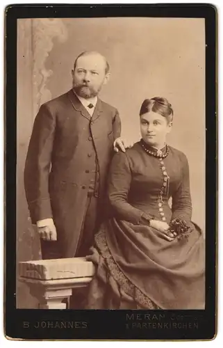 Fotografie B. Johannes, Meran /Obermais, Portrait bürgerliches Paar in hübscher Kleidung