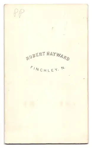 Fotografie Robert Hayward, Finchley, Portrait junger Knabe im grauen Anzug an einen Sekretär gelehnt