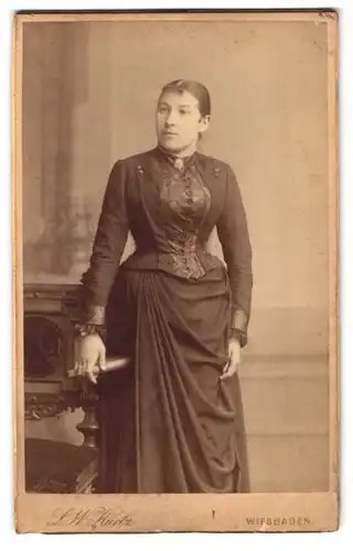 Fotografie L. W. Kurtz, Wiesbaden, Friedrichstr. 4, junge Dame im tailierten Kleid mit Edelweiss-Brosche