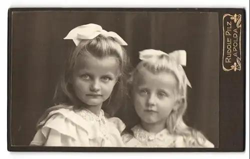 Fotografie Rudolf Pilz, Apolda, Ackerwandstr. 34, Portrait zwei niedliche Mädchen in weissen Kleidern mit Haarschleifen