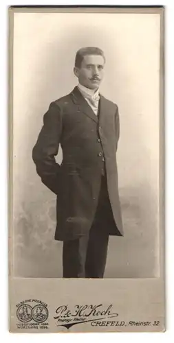 Fotografie P. & H. Koch, Crefeld, Rheinstr. 32, Portrait Herr mit Schnauzbart trägt Anzug & Krawatte