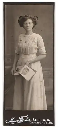 Fotografie Max Fischer, Berlin, Invalidenstr. 164, junge Dame mit Katalog im weissen Kleid