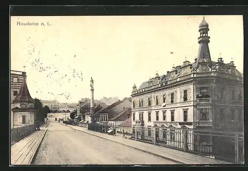 AK Roudnice n. L., Strassenpartie mit Gebäudeansicht und Denkmal