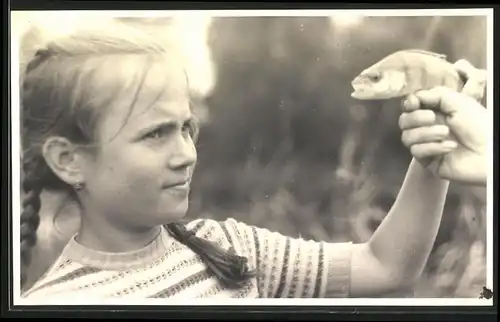 Fotografie Mädchen beim Angeln mit ihrem ersten Fisch - Flussbarsch