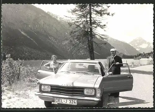 Fotografie Auto Ford, Paar mit PKW vor Gebirgsmassiv