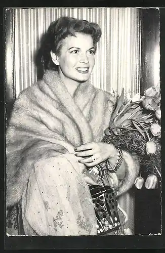 AK Schauspielerin Eva Bartok mit eleganter Pelzstola und Blumen im Arm